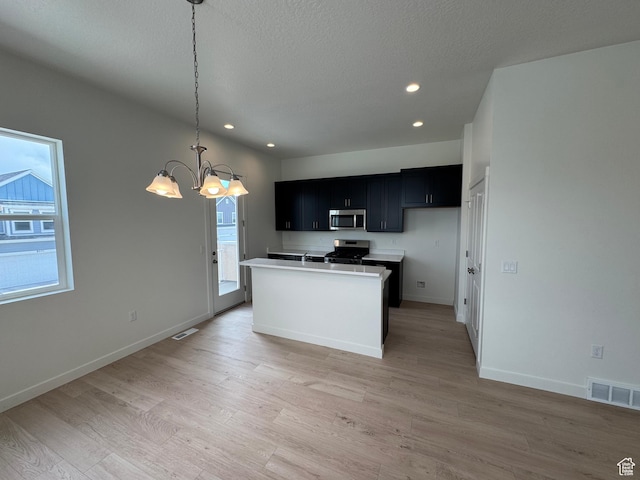 1668 N 1600 W Unit 128, Layton, UT 84041 - kitchen featuring appliances with stainless steel finishes, dark cabinets, a chandelier, light wood-style floors, and recessed lighting