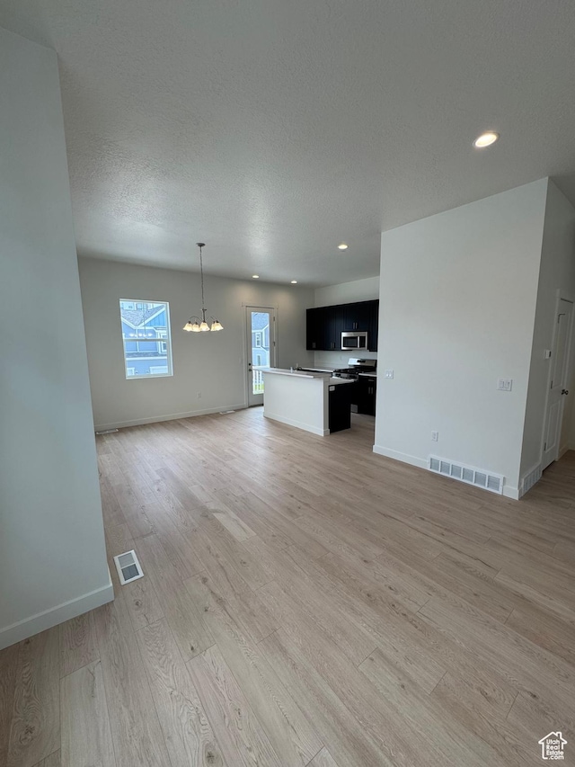 1668 N 1600 W Unit 128, Layton, UT 84041 - unfurnished living room with a chandelier, light wood-type flooring, recessed lighting, and a textured ceiling