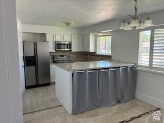 686 N 500 W, Orem, UT 84057 - kitchen featuring appliances with stainless steel finishes, a chandelier, a peninsula, light countertops, and white cabinets