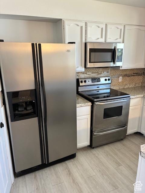 686 N 500 W, Orem, UT 84057 - kitchen featuring appliances with stainless steel finishes, white cabinetry, tasteful backsplash, light wood-style floors, and light stone counters