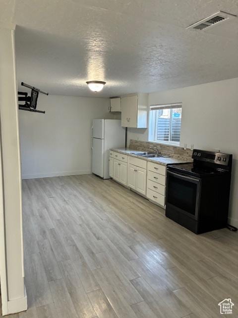 686 N 500 W, Orem, UT 84057 - kitchen featuring black electric range oven, freestanding refrigerator, a textured ceiling, light wood finished floors, and light countertops