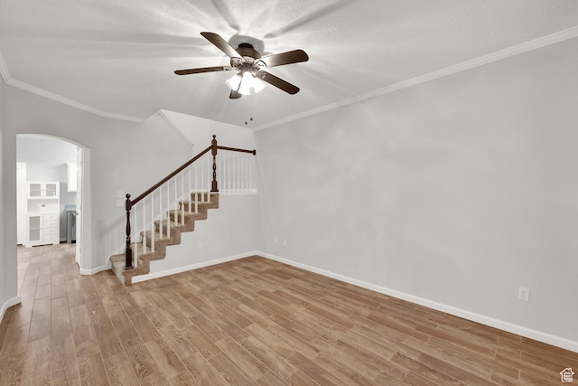 8728 S Black Diamond Cv W, West Jordan, UT 84081 - spare room featuring arched walkways, stairway, light wood-type flooring, ceiling fan, and crown molding
