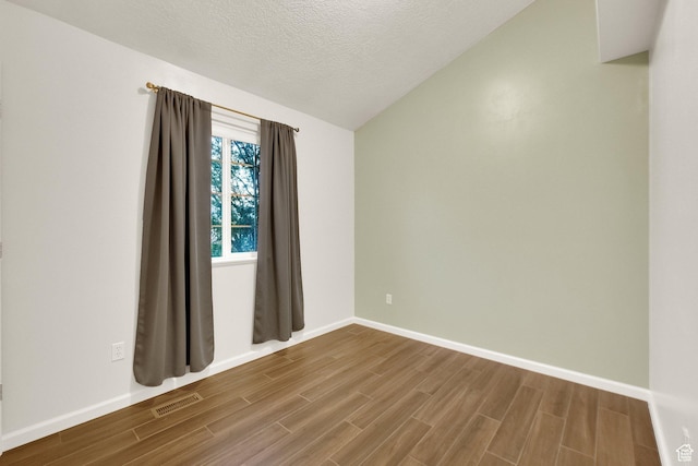 8728 S Black Diamond Cv W, West Jordan, UT 84081 - spare room featuring vaulted ceiling, wood finished floors, and a textured ceiling