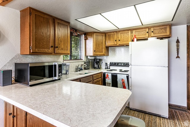 1922 N Corral Rd Unit 10, Scofield, UT 84526 - kitchen featuring white appliances, a peninsula, light countertops, brown cabinets, and a textured ceiling