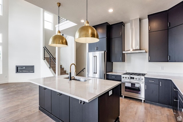 392 W Ascent Dr Unit 255, Hideout, UT 84036 - kitchen with appliances with stainless steel finishes, wall chimney exhaust hood, light wood-style floors, pendant lighting, and recessed lighting