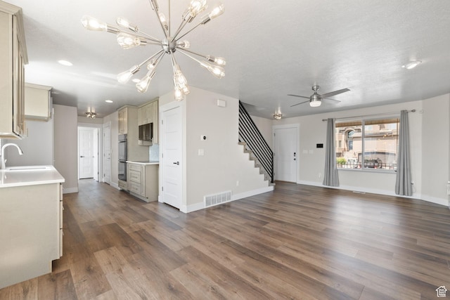 6959 S Adventure Way, West Jordan, UT 84081 - unfurnished living room featuring stairs, dark wood-style flooring, a ceiling fan, a chandelier, and recessed lighting