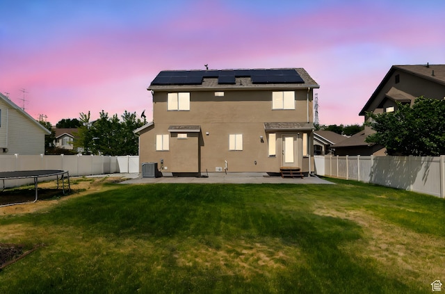 6959 S Adventure Way, West Jordan, UT 84081 - back of property with a trampoline, entry steps, a patio area, a fenced backyard, and solar panels