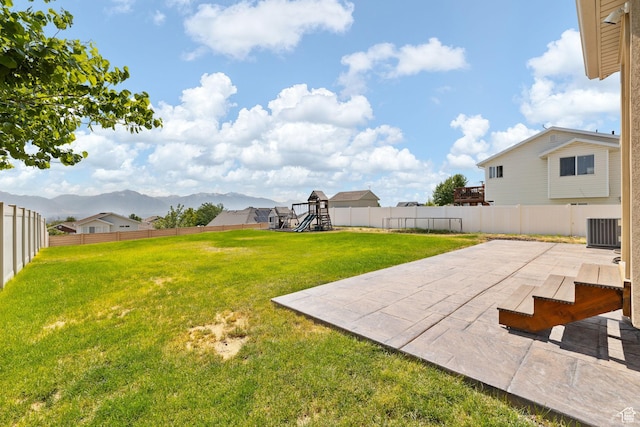 6959 S Adventure Way, West Jordan, UT 84081 - fenced backyard with a playground, a patio area, and a mountain view