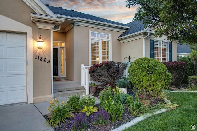 11863 S Cottage Side Way, Draper, UT 84020 - exterior entry at dusk with stucco siding, a shingled roof, and a garage