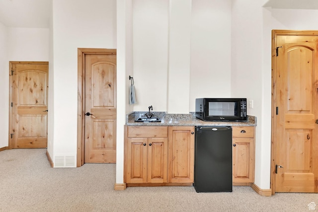 5176 E Fairview Loop Unit C505, Eden, UT 84310 - kitchen with black microwave, fridge, light carpet, light stone countertops, and light brown cabinetry