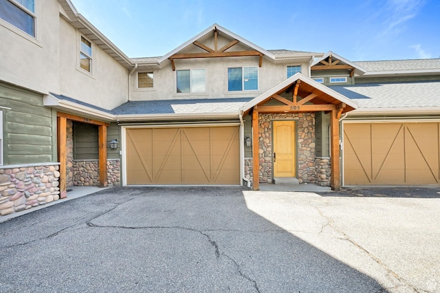 5176 E Fairview Loop Unit C505, Eden, UT 84310 - view of front of property with stone siding, stucco siding, a garage, and driveway