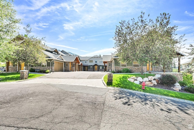 5176 E Fairview Loop Unit C505, Eden, UT 84310 - view of front of home featuring stone siding, a garage, driveway, and a front yard