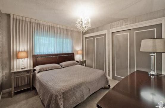 1150 E 2700 S Unit 50G, Salt Lake City, UT 84106 - bedroom with two closets, carpet, and a chandelier