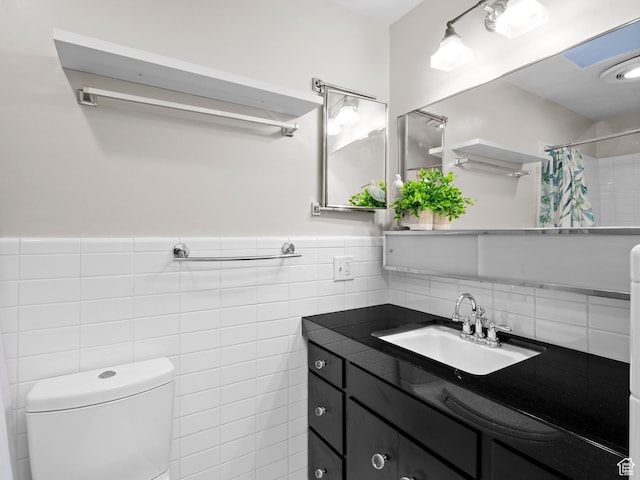 1150 E 2700 S Unit 50G, Salt Lake City, UT 84106 - full bathroom with tile walls, vanity, curtained shower, and a wainscoted wall