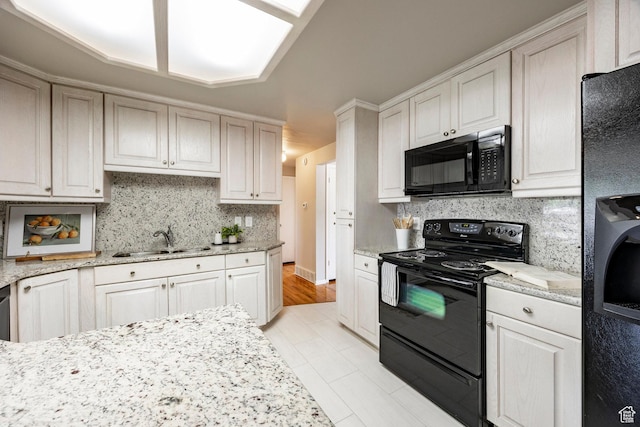 8097 S 535 E, Sandy, UT 84070 - kitchen featuring black appliances, backsplash, light stone counters, light tile patterned flooring, and washer / dryer