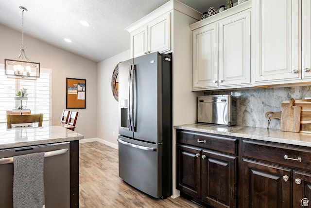 2402 W 525 S, Layton, UT 84041 - kitchen featuring stainless steel appliances, a chandelier, dark brown cabinetry, vaulted ceiling, and decorative backsplash