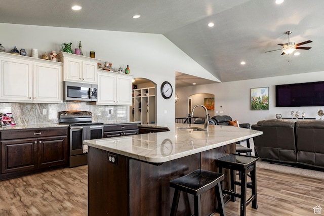 2402 W 525 S, Layton, UT 84041 - kitchen with appliances with stainless steel finishes, arched walkways, open floor plan, lofted ceiling, and light wood finished floors