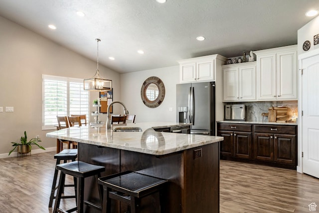 2402 W 525 S, Layton, UT 84041 - kitchen with stainless steel fridge with ice dispenser, a kitchen bar, wood finished floors, recessed lighting, and white cabinetry