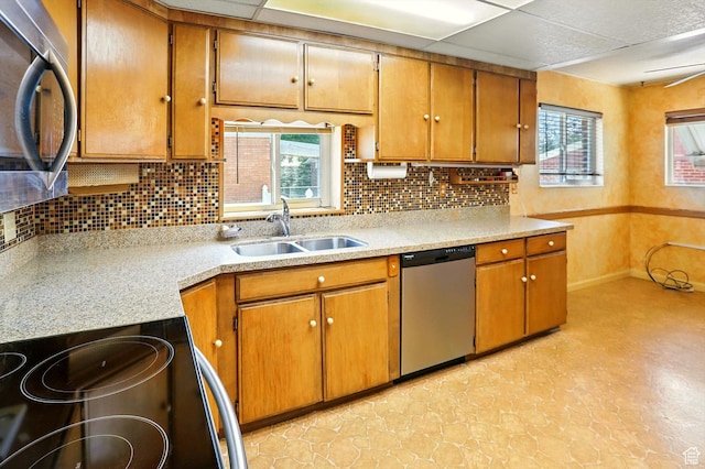 1743 N 250 W, Sunset, UT 84015 - kitchen with appliances with stainless steel finishes, light countertops, backsplash, and brown cabinetry