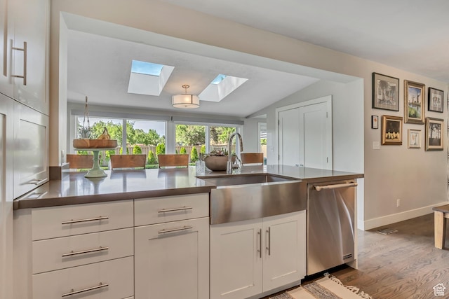 2241 E Melodie Ann Way, Holladay, UT 84124 - kitchen featuring stainless steel dishwasher, a skylight, wood finished floors, white cabinetry, and vaulted ceiling