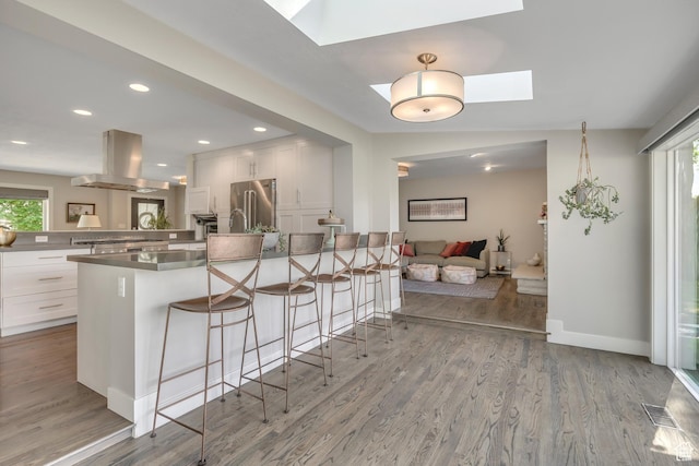 2241 E Melodie Ann Way, Holladay, UT 84124 - kitchen with island range hood, high end fridge, a peninsula, a breakfast bar area, and a skylight