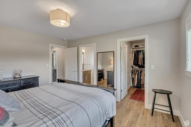 2241 E Melodie Ann Way, Holladay, UT 84124 - bedroom featuring a walk in closet, light wood-type flooring, a closet, and ensuite bathroom