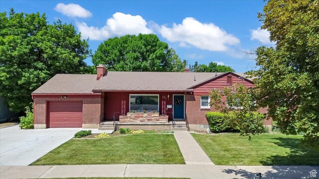 871 N 400 E, Logan, UT 84321 - single story home with an attached garage, a chimney, driveway, brick siding, and a front lawn