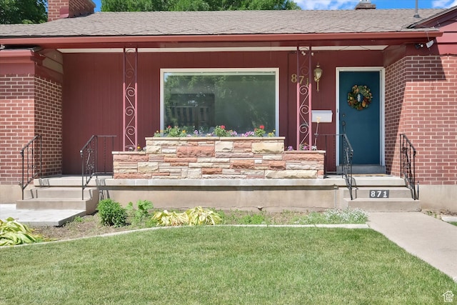 871 N 400 E, Logan, UT 84321 - doorway to property featuring a chimney, brick siding, and a lawn