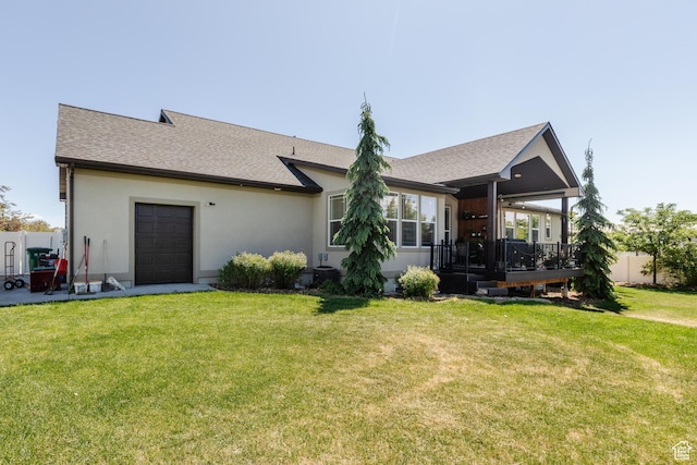 981 E Pebble Creek Rd, Smithfield, UT 84335 - rear view of property with a lawn, a deck, stucco siding, a garage, and roof with shingles