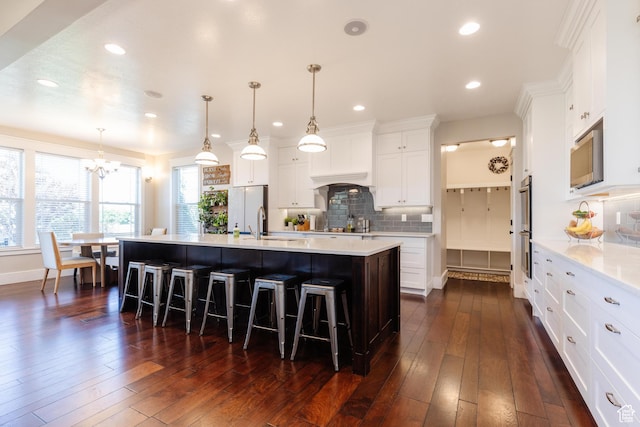 981 E Pebble Creek Rd, Smithfield, UT 84335 - kitchen with appliances with stainless steel finishes, a chandelier, a kitchen breakfast bar, light countertops, and backsplash