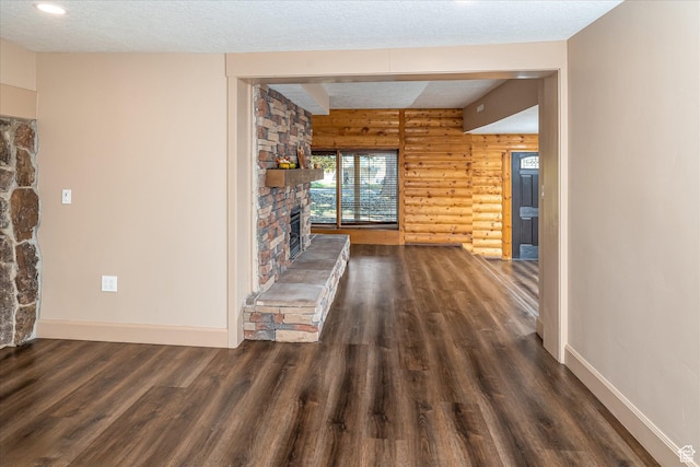 210 S 100 E, Fielding, UT 84311 - unfurnished living room with rustic walls, wood finished floors, a stone fireplace, and a textured ceiling