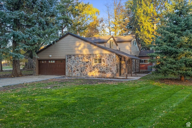 210 S 100 E, Fielding, UT 84311 - view of property exterior featuring a lawn, a garage, driveway, and stone siding