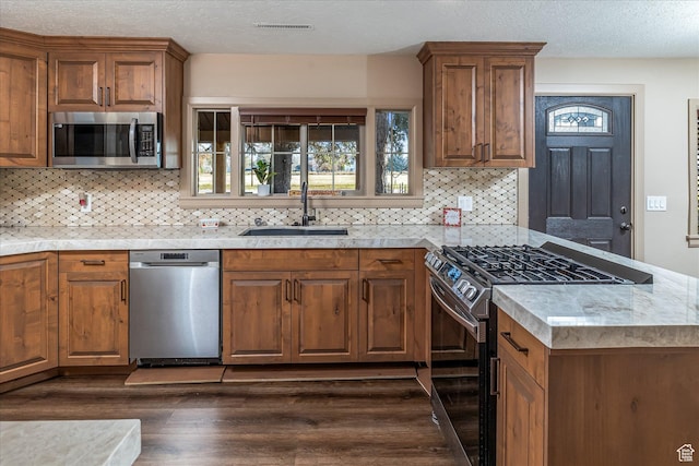 210 S 100 E, Fielding, UT 84311 - kitchen featuring appliances with stainless steel finishes, dark wood-style flooring, brown cabinetry, and a textured ceiling