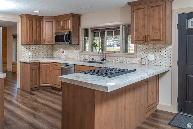 210 S 100 E, Fielding, UT 84311 - kitchen with appliances with stainless steel finishes, a peninsula, light countertops, dark wood finished floors, and a textured ceiling