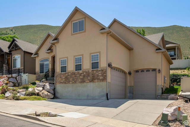 258 E Red Leaf Dr, Draper, UT 84020 - view of front of property featuring stone siding, driveway, a mountain view, a garage, and stucco siding