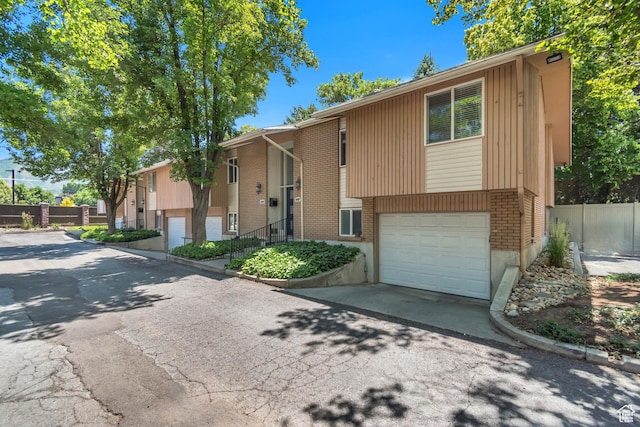 4797 S 2124 E, Holladay, UT 84117 - bi-level home featuring an attached garage, driveway, and brick siding