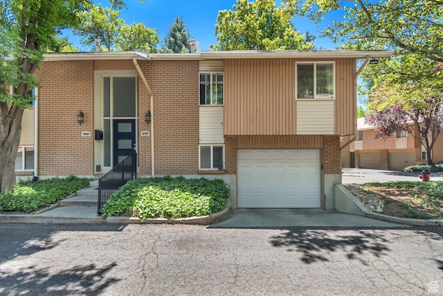 4797 S 2124 E, Holladay, UT 84117 - view of front of home with brick siding, an attached garage, and asphalt driveway