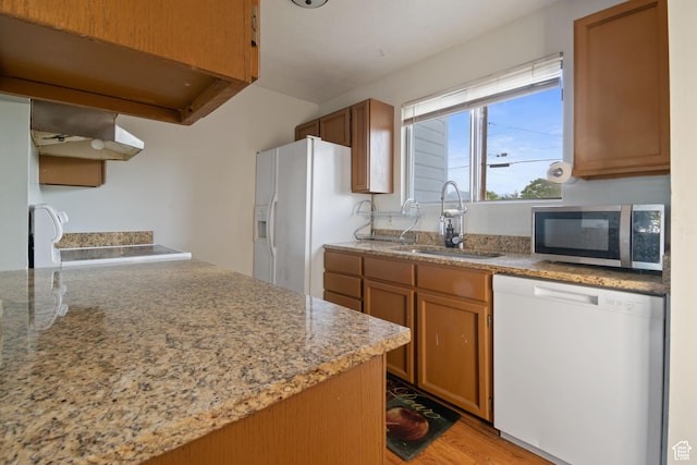 3638 Oldham Cir, West Valley City, UT 84120 - kitchen with white appliances, under cabinet range hood, light wood-style floors, and brown cabinets