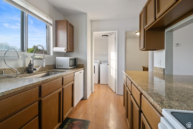 3638 Oldham Cir, West Valley City, UT 84120 - kitchen featuring stainless steel microwave, washer and clothes dryer, dishwasher, stone countertops, and light wood-style floors