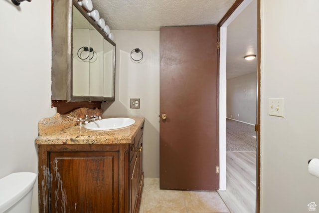 3638 Oldham Cir, West Valley City, UT 84120 - half bath featuring vanity, a textured ceiling, and tile patterned flooring