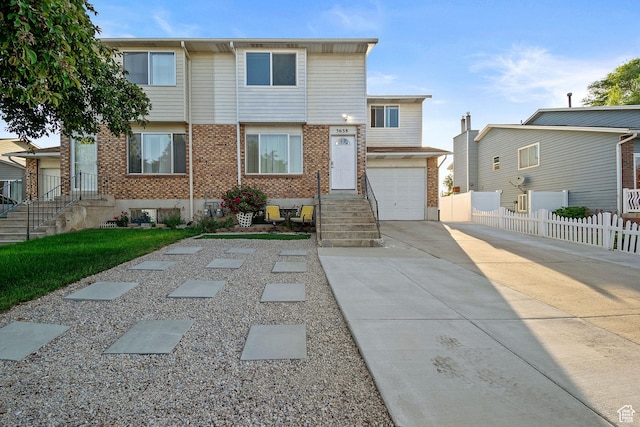 3638 Oldham Cir, West Valley City, UT 84120 - view of property featuring brick siding, driveway, and an attached garage