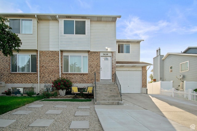 3638 Oldham Cir, West Valley City, UT 84120 - townhome / multi-family property featuring concrete driveway, brick siding, and a garage