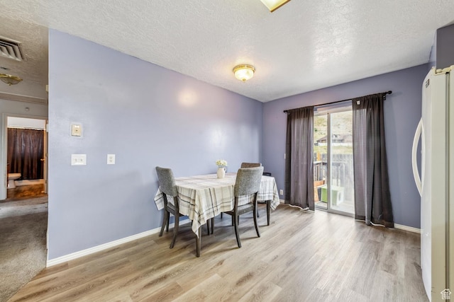 615 W 1080 S, Tooele, UT 84074 - dining room featuring a textured ceiling and light wood-style flooring