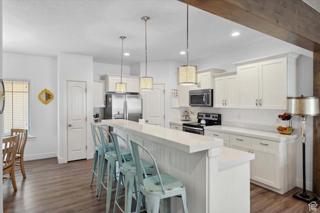 5538 N Turin Ln, Highland, UT 84003 - kitchen featuring appliances with stainless steel finishes, a center island, white cabinetry, light countertops, and a breakfast bar area