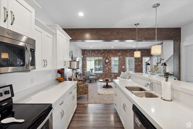 5538 N Turin Ln, Highland, UT 84003 - kitchen featuring appliances with stainless steel finishes, brick wall, open floor plan, dark wood-style flooring, and light countertops