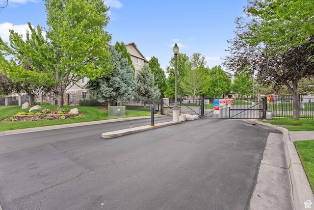 1205 E Privet Dr S Unit 101, Cottonwood Heights, UT 84121 - view of asphalt road with a gate, street lights, a gated entry, and curbs