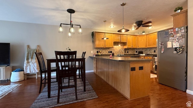 1205 E Privet Dr S Unit 101, Cottonwood Heights, UT 84121 - kitchen with freestanding refrigerator, a peninsula, dark countertops, ceiling fan, and dark wood-type flooring