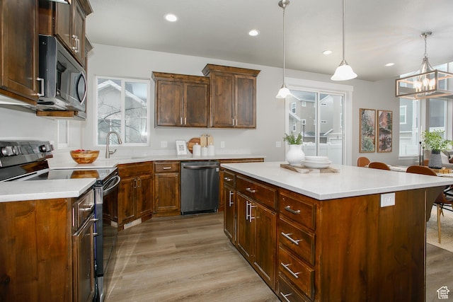 5001 W Anegada Ln S, Herriman, UT 84096 - kitchen with appliances with stainless steel finishes, light wood finished floors, light countertops, decorative light fixtures, and recessed lighting