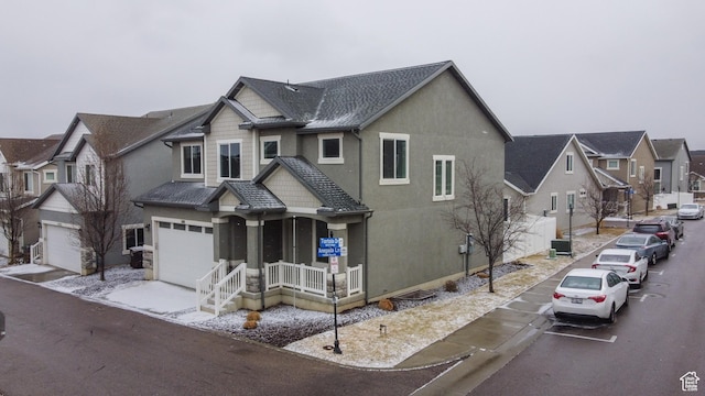 5001 W Anegada Ln S, Herriman, UT 84096 - view of front of home with covered porch, an attached garage, stucco siding, and roof with shingles