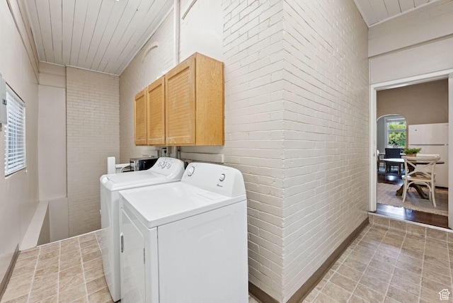 921 E 800 S, Salt Lake City, UT 84102 - laundry room featuring washer and clothes dryer, cabinet space, brick wall, arched walkways, and light tile patterned floors